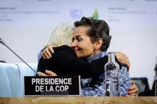 Two negotiators hug at COP21