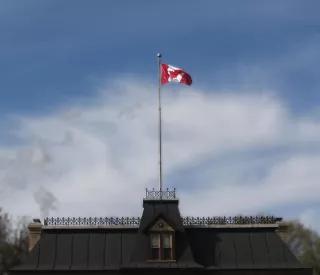 A Canadian flag in the wind above a building