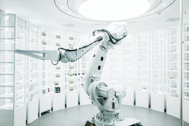 robotic arm grabs things from shelves in brightly lit white room