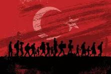 Refugees walking in front of a Turkish flag