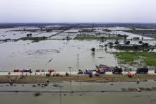 photo of aid being dropped off on a road elevated above flooding in Pakistan