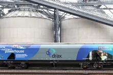 train in front of large storage containers