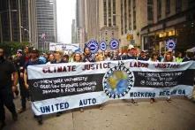 union workers march with a banner that says "climate justice is labor justice"