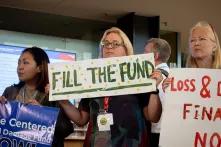 protestors hold up signs at TC meeting in Bonn