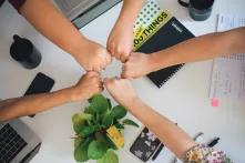 women holding hands over a work desk