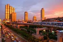 skyscrapers behind a busy road and light rail