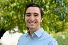 headshot of ben davis in front of green, leafy background