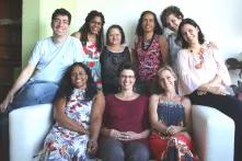 diverse group of people sitting on and standing behind a couch in an office