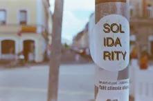 two stickes on a pole that say "solidarity" and "be part of cool resistance...fight climate change"