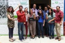 diverse group of people stand before a door into an office building
