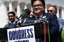 man standing at a podium with microphones and a sign that says "congress union" in front of the Capitol Building