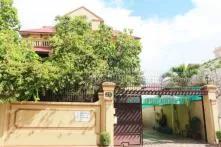 front of building with a courtyard on the left and gate on the right