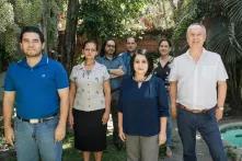 diverse group of people stand in a courtyard with a fountain and trees