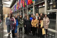 women stand in front of flags at State Department in Washington, DC