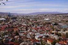 large sprawling city with a few tall buildings and mountains in the background