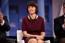 woman sitting on a panel with blue background