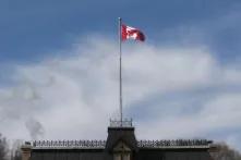A Canadian flag in the wind above a building