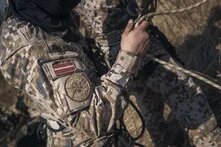 A Latvian soldier at a training exercise holds a rope