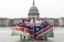 five draq queens hold the Kenyan and Namibian flags in front of the US Capitol