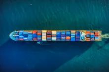 full container ship moves across the ocean, from directly above