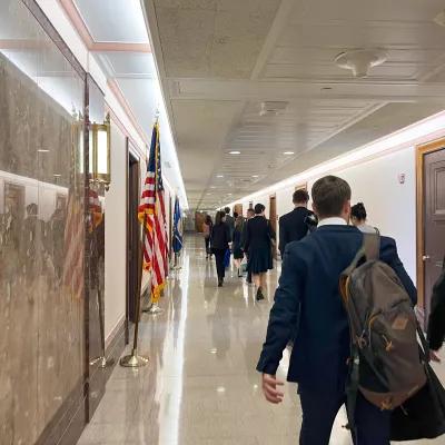The participants of the Study Tour are walking through a Capitol office building