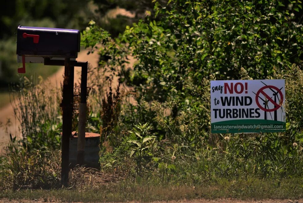 rural road with mailbox and sign that says "say no! to wind turbines"