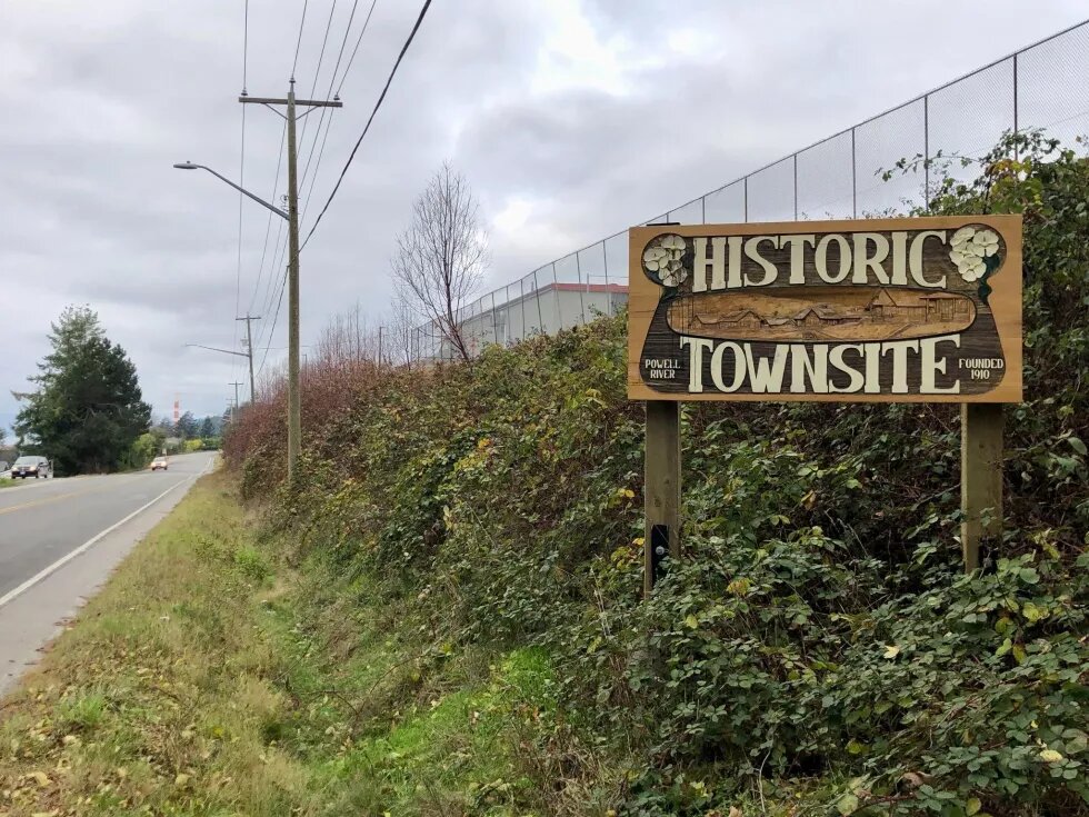sign that says "historic townsite" on a bank next to a road