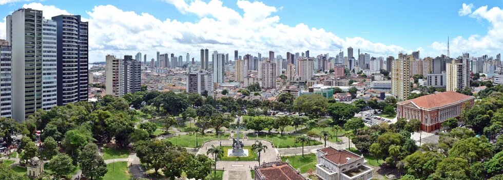 a large green, tropical park surrounded by tall buildings in Belém