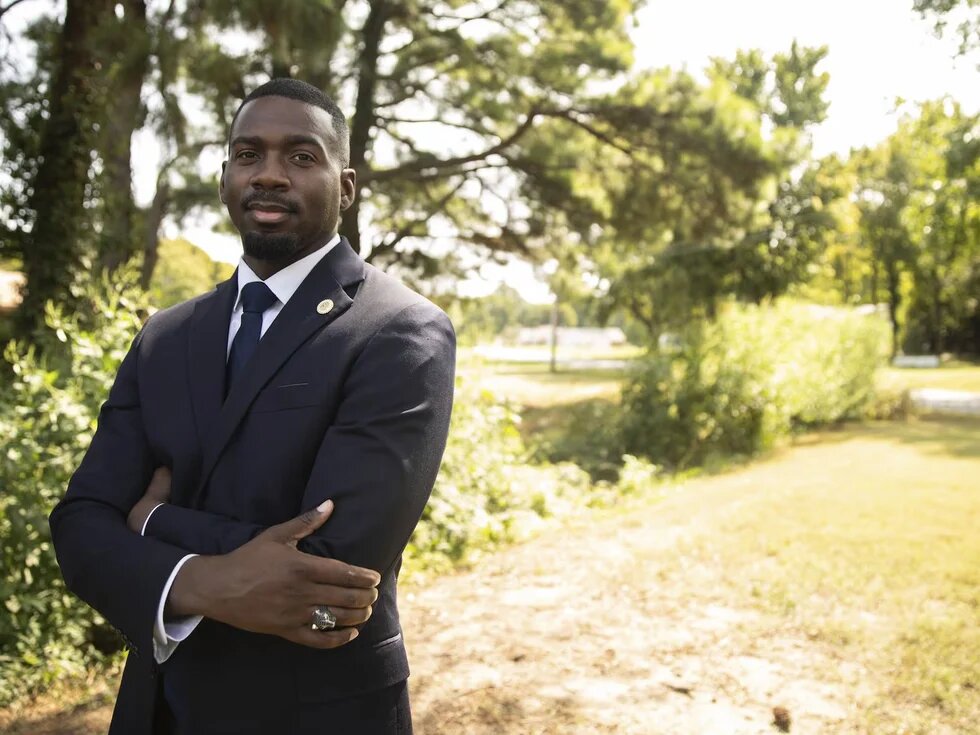 KeShaun Pearson in a suit outside on a sunny day