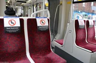 Chairs on Toronto public transit have signs reminding riders to physically distance themselves