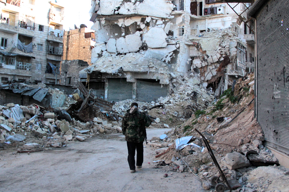 Syria: two years of tragedy A man stands in front of rubble.